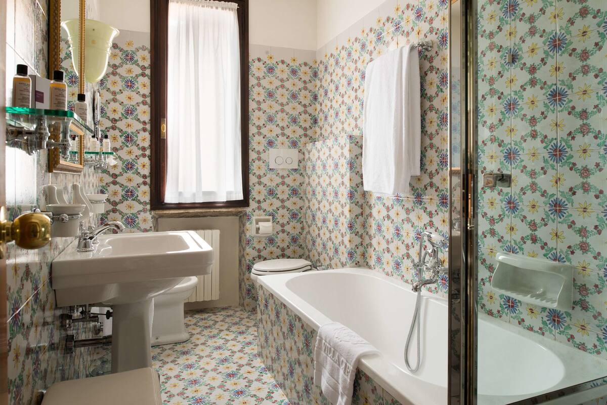 junior suite (premier) | bathroom | combined shower/bathtub, rainfall showerhead, free toiletries