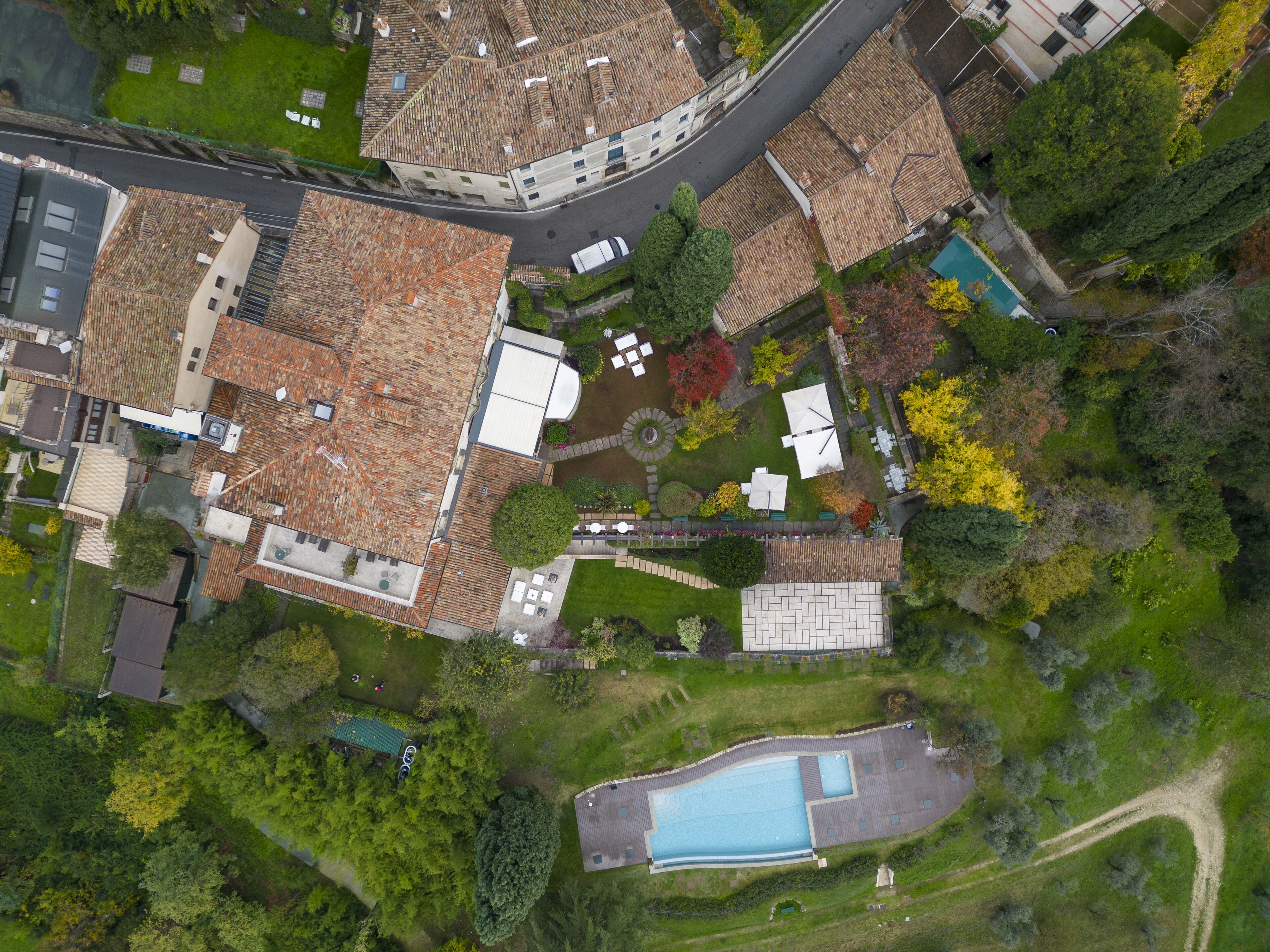 Vue aérienne d’un quartier résidentiel avec de nombreuses maisons, une piscine et une route sinueuse.
