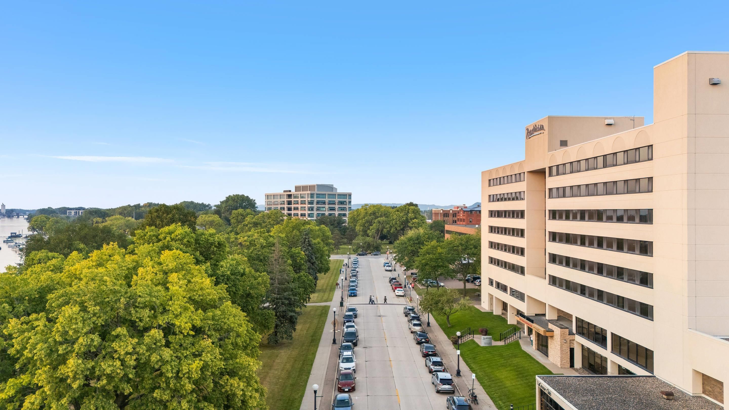 A parking lot with cars, a building with a sign, and a river in the background.