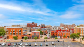 A cityscape with multiple buildings, a parking lot, and a clear sky.