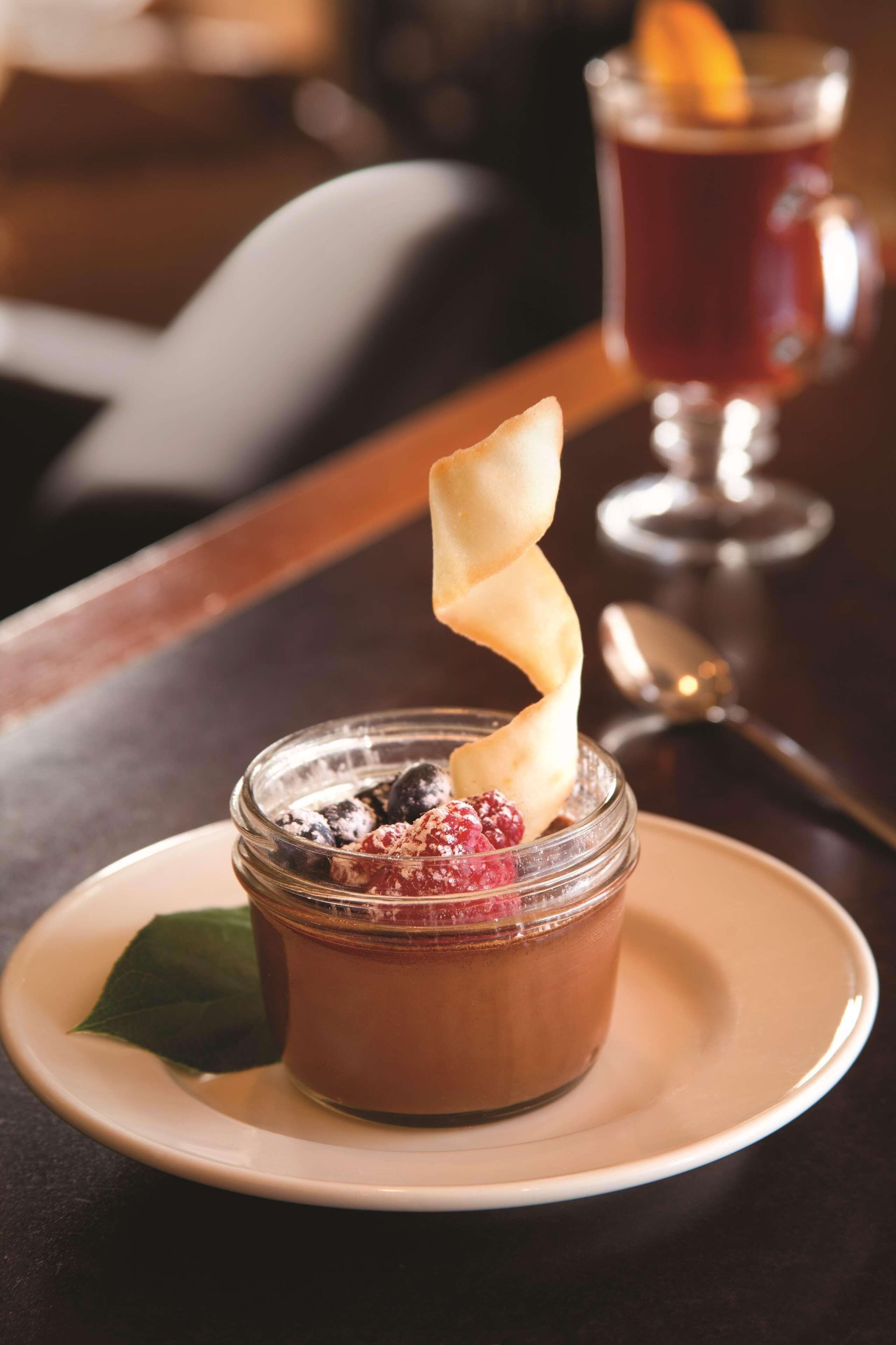 A dessert on a plate with a leaf garnish.