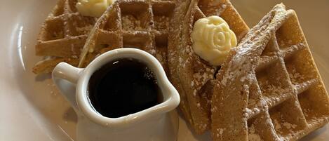 Een bord met wafels en siroop.