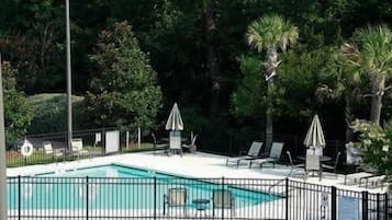 Una piscina al aire libre, sillones reclinables de piscina