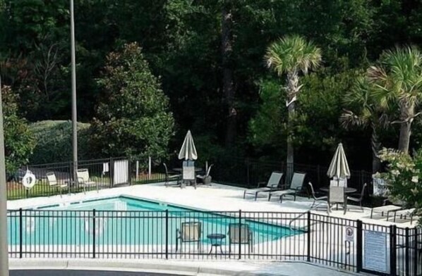 Una piscina al aire libre, sillones reclinables de piscina