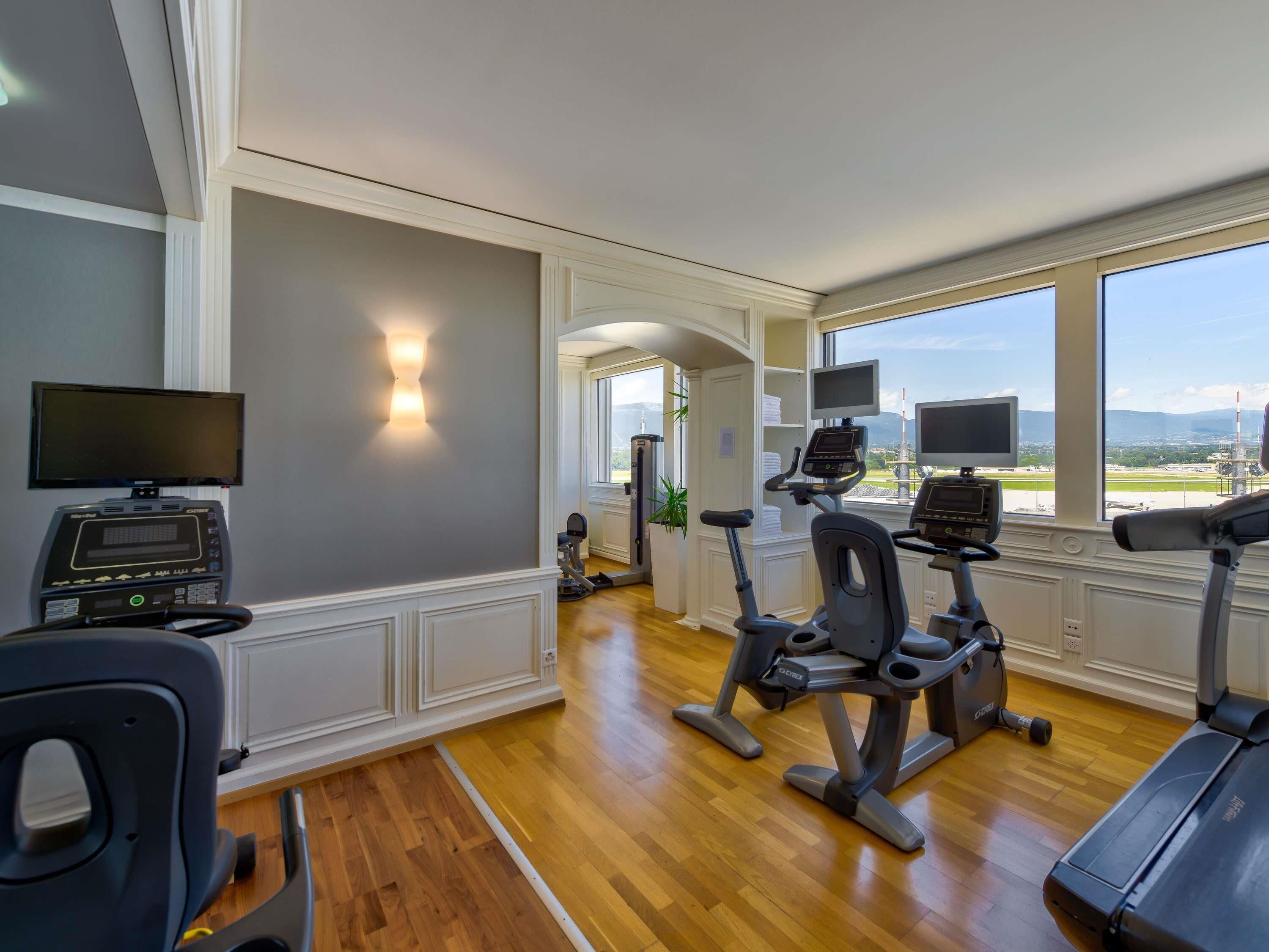 A gym with exercise equipment, a treadmill, and a stationary bike.