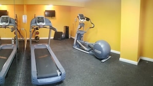 A fitness room with treadmills, an elliptical, and a stationary bike.
