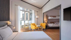 A hotel room with a large bed, two yellow armchairs, a small table, a balcony with curtains, and a separate sleeping area with a bunk bed. - Hotel Madrid Plaza de España Affiliated by Meliá (Madrid)