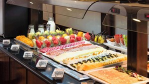 A buffet with various food items including fruits, cheeses, and meats. - Hotel Madrid Plaza de España Affiliated by Meliá (Madrid)