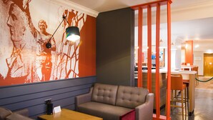A modern interior with a sofa, a table, and a bar area. - Holiday Inn Stoke on Trent M6, Jct 15 by IHG (Newcastle-Under-Lyme)