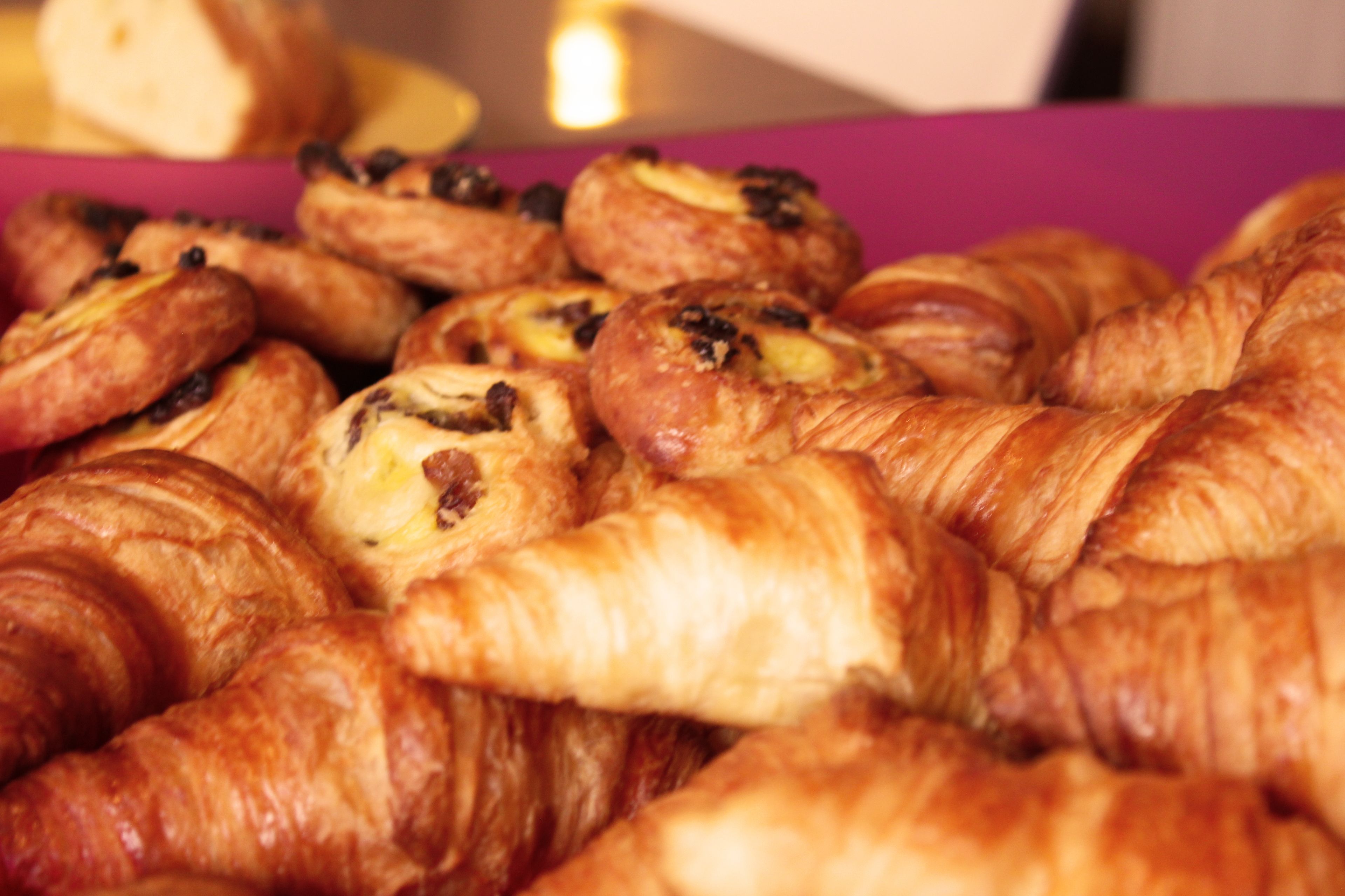 A box of assorted pastries, including croissants and chocolate-filled pastries.