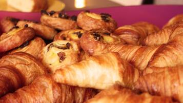 A box of assorted pastries, including croissants and chocolate-filled pastries.