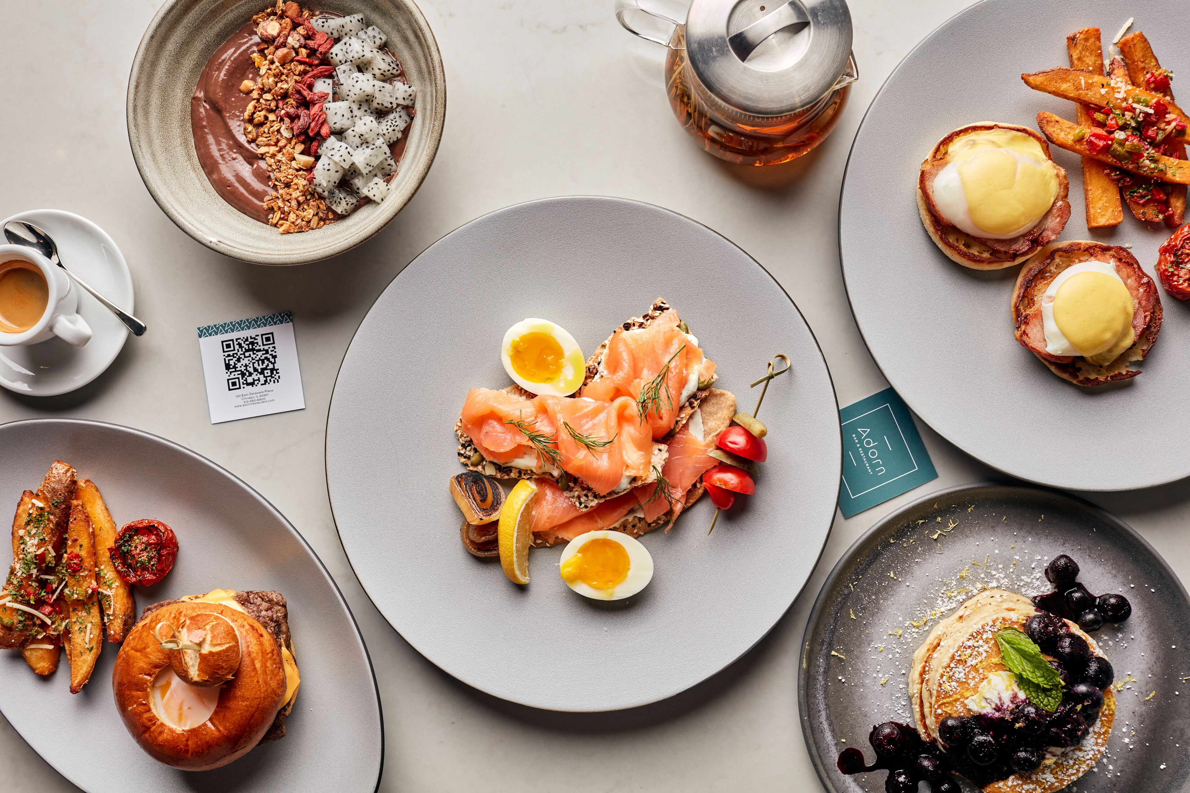 Diversos platos de desayuno, como huevos, salmón ahumado y fruta.