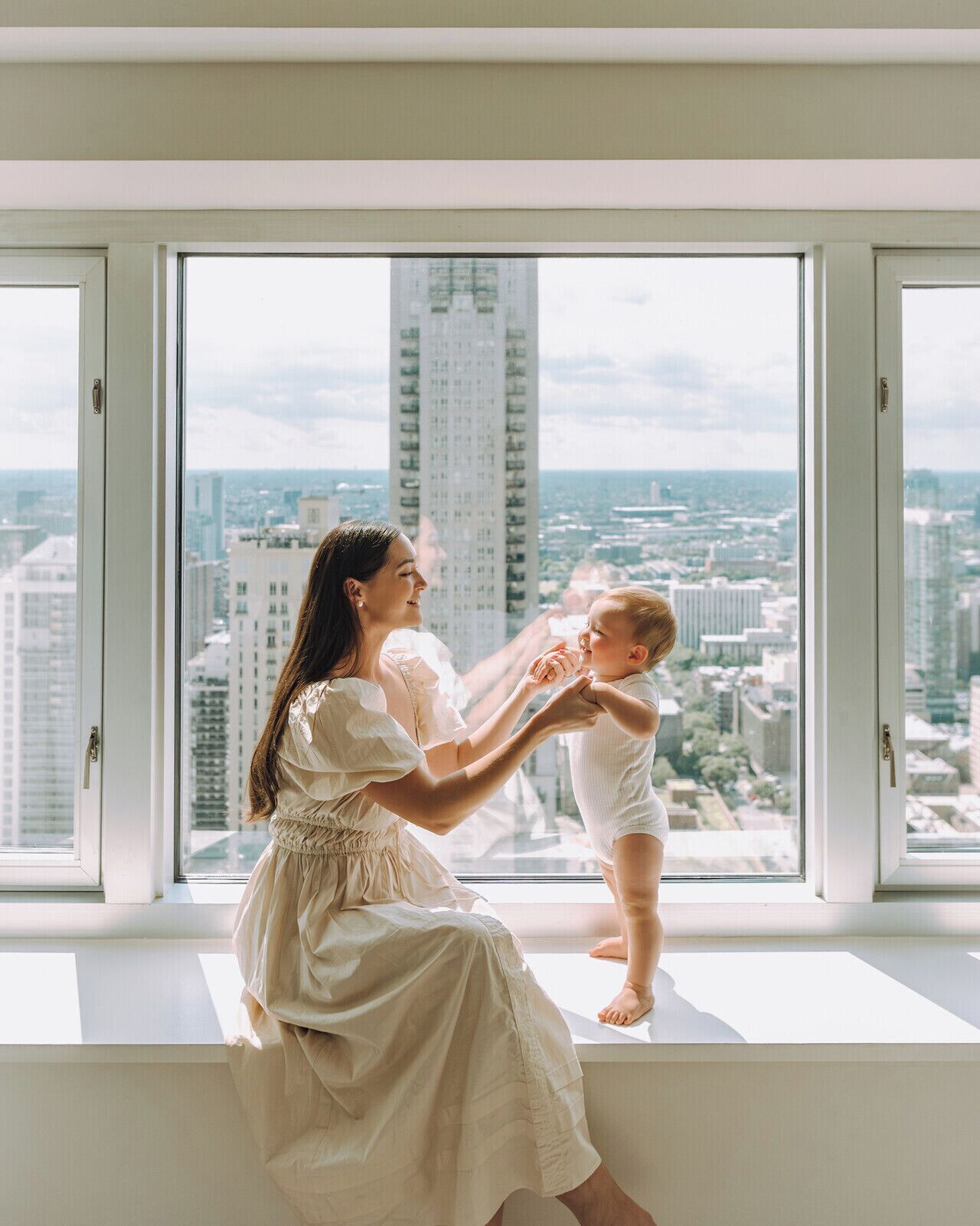 A room with a large window overlooking a cityscape.