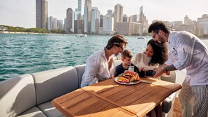 A group of people on a boat with a city skyline in the background. - Four Seasons Hotel Chicago (Chicago)