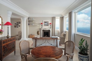 A spacious living room with a fireplace, a round wooden table, and comfortable seating.
