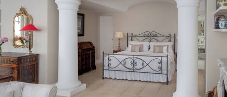 A bedroom with a bed, a dresser, and a mirror.