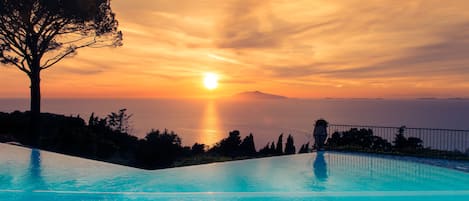 Una piscina al aire libre, sombrillas, tumbonas