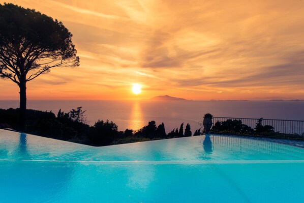 Una piscina al aire libre, sombrillas, tumbonas