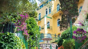 Una escalera de piedra que sube hacia un edificio amarillo con un balcón.