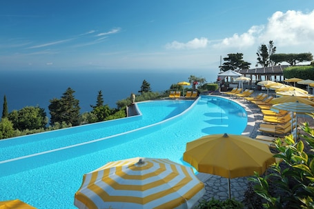 Outdoor pool, pool umbrellas, sun loungers. Caesar Augustus, Relais & Chateaux Hotel