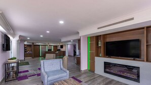 Una sala de estar moderna con televisor de pantalla plana, chimenea y un espacio de descanso acogedor.