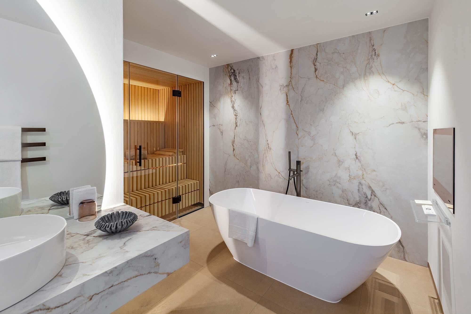 Une salle de bain moderne avec une baignoire sur pieds, des comptoirs en marbre et un mur revêtu de panneaux en bois.