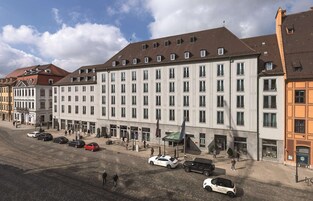 Un hotel de varios pisos con una hilera de ventanas uniformes y una entrada central.