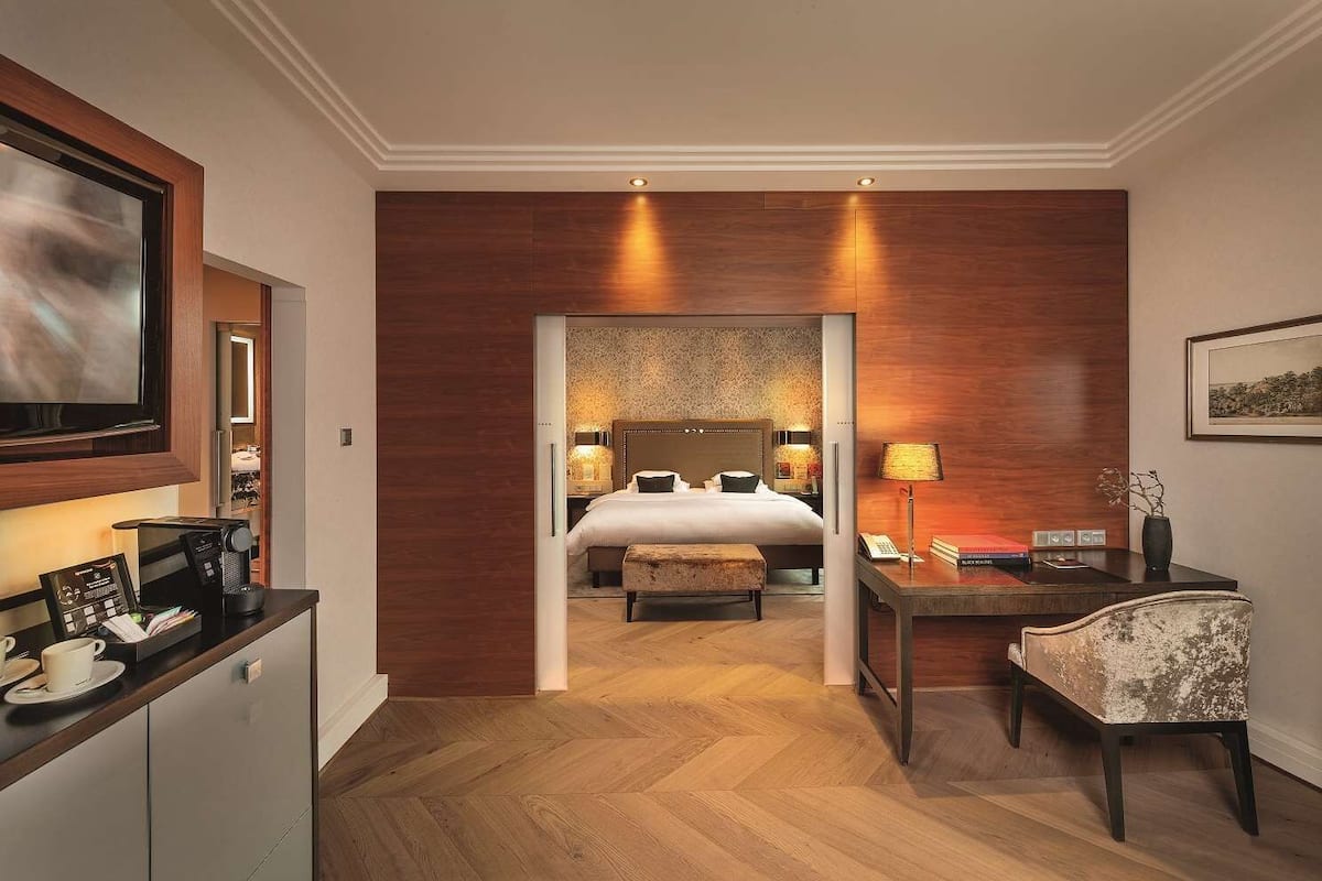Une chambre d’hôtel équipée d’un lit, d’un bureau, d’une chaise, d’une machine à café et d’un téléviseur.