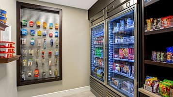 A vending area with snack and drink options, including a refrigerated section with beverages and a wall-mounted display of snacks.