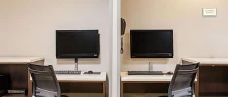 Un bureau aménagé de manière symétrique, avec deux bureaux, chacun équipé d’un écran d’ordinateur, d’un clavier et d’une chaise.