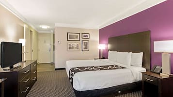 A hotel room with a bed, a TV, a desk, and a nightstand.