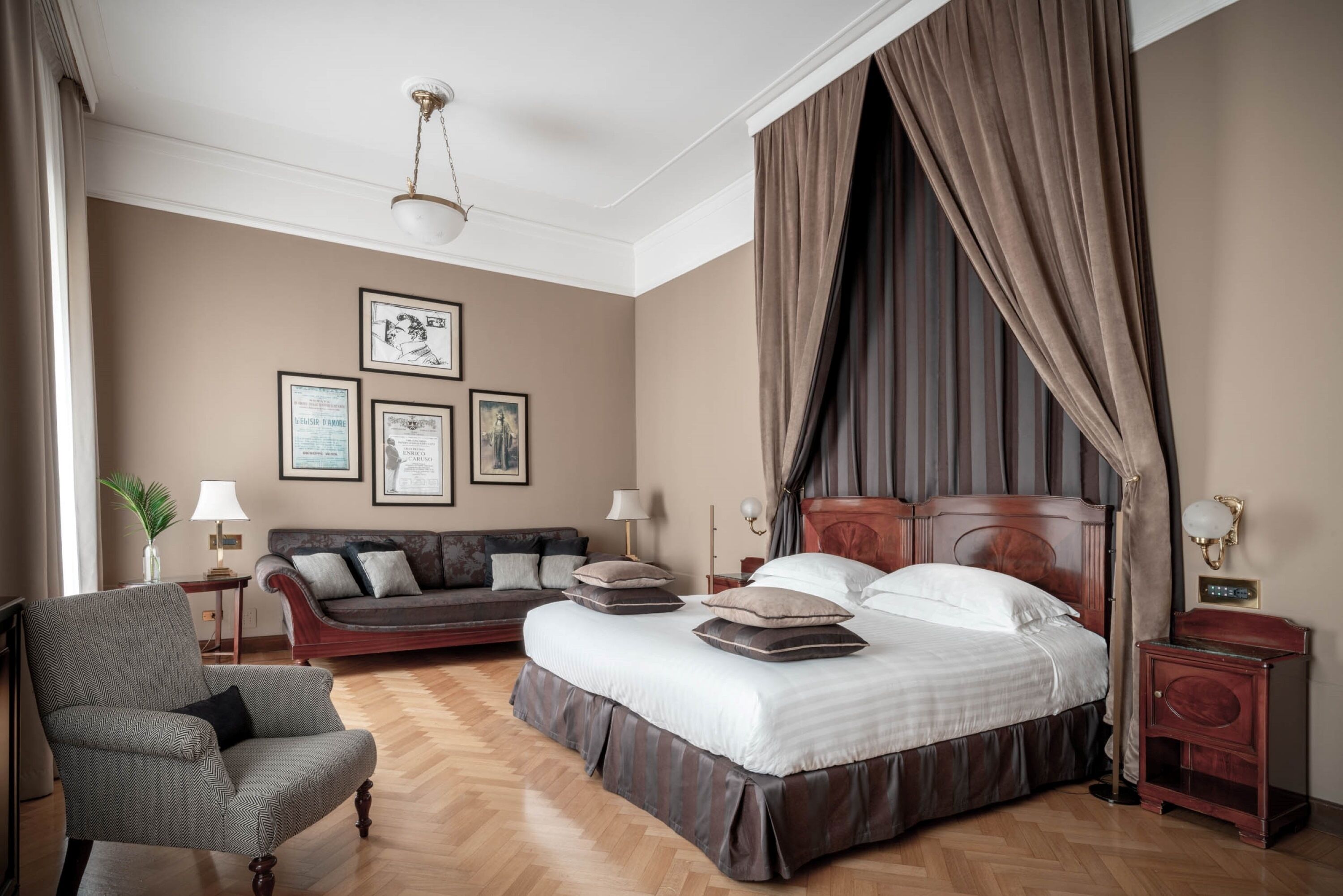 A bedroom with a large bed, a sofa, a chair, and a nightstand.