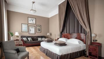 A bedroom with a large bed, a sofa, a chair, and a nightstand.