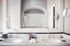A bathroom with two sinks, a large mirror, and a towel rack.