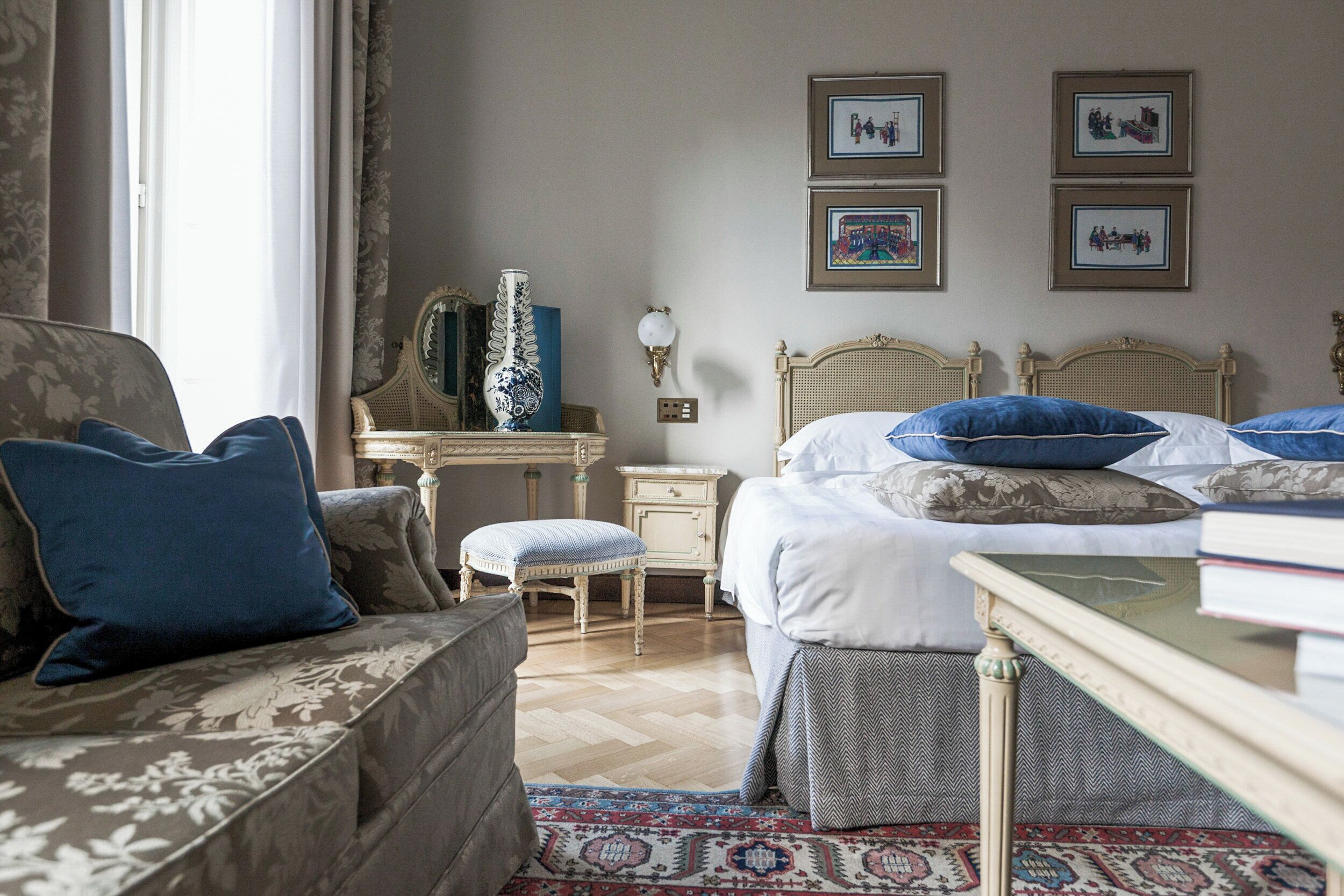A bedroom with a bed, a chair, a nightstand, a dresser, and a mirror.