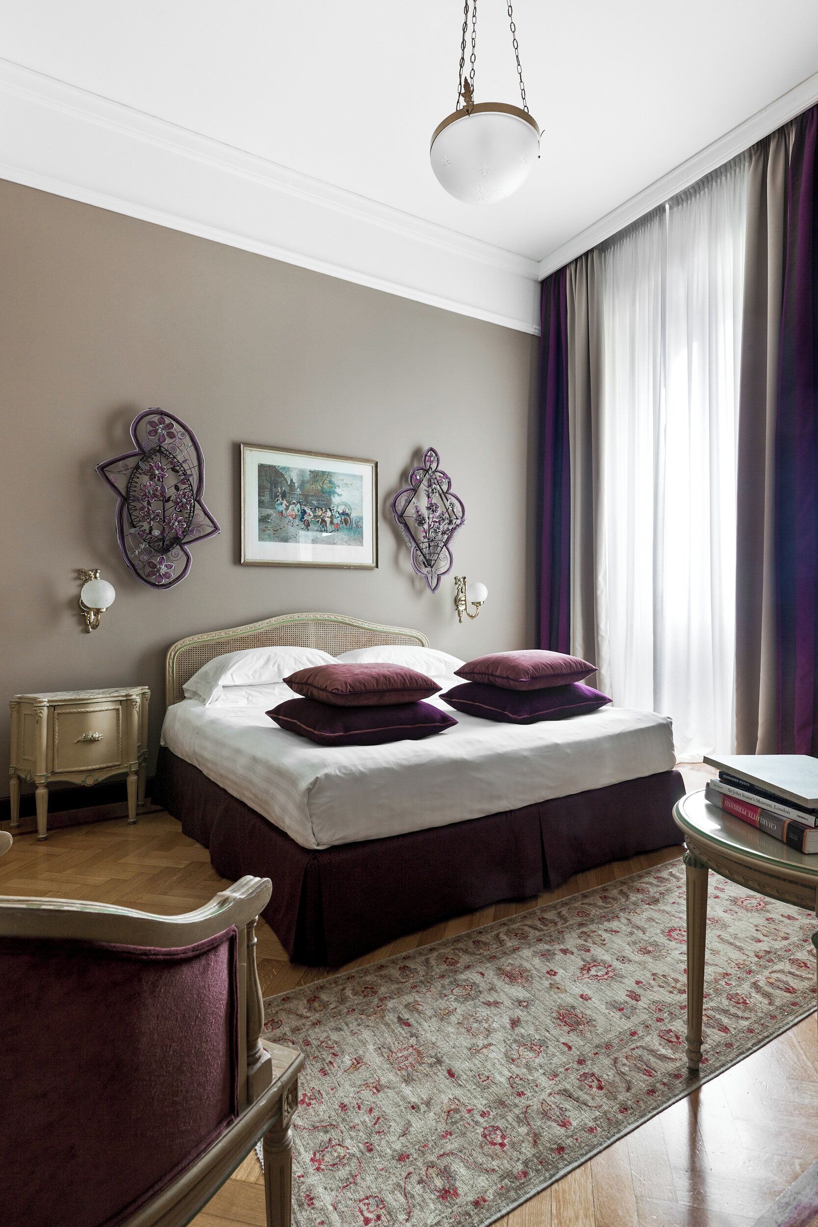 Une chambre à coucher bien rangée, avec un lit, une table de chevet, une chaise, une table et un luminaire suspendu.