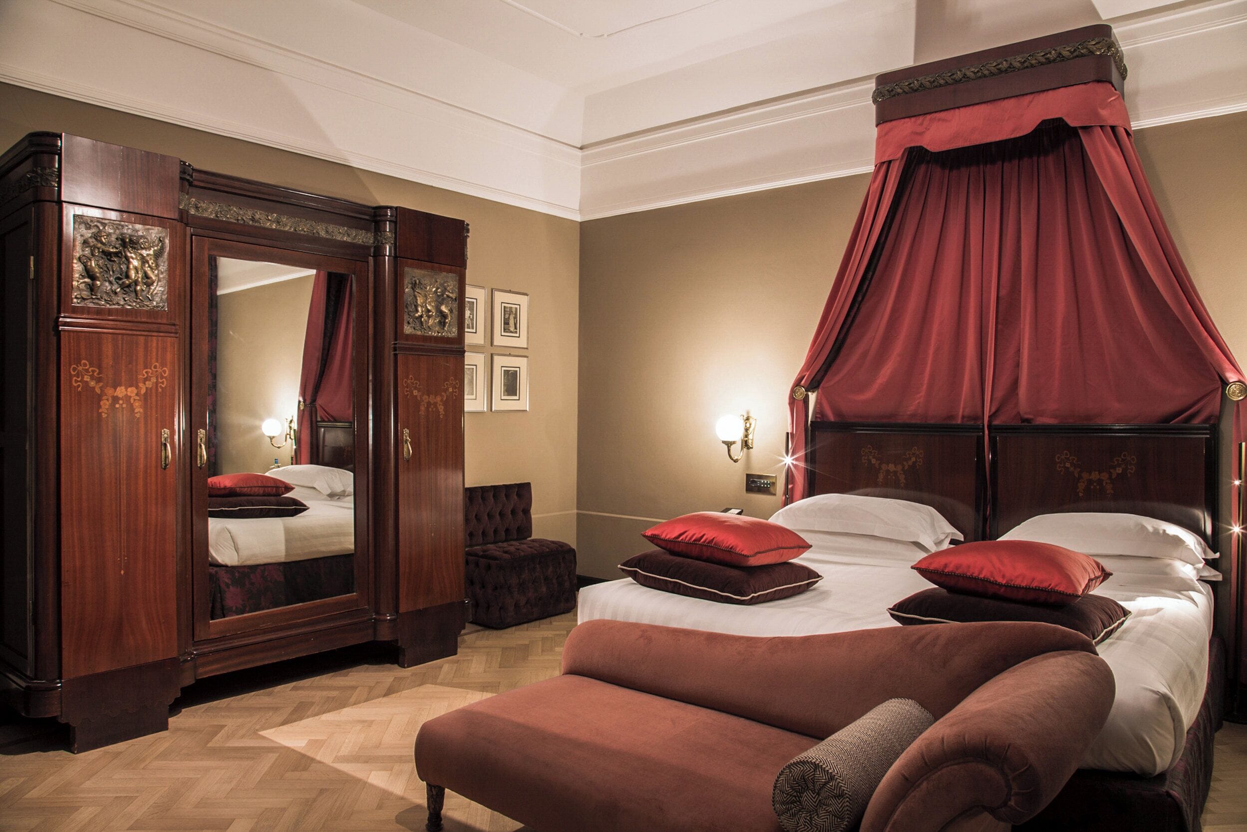 Une chambre à coucher avec un lit à baldaquin, un grand miroir et un dais rouge.