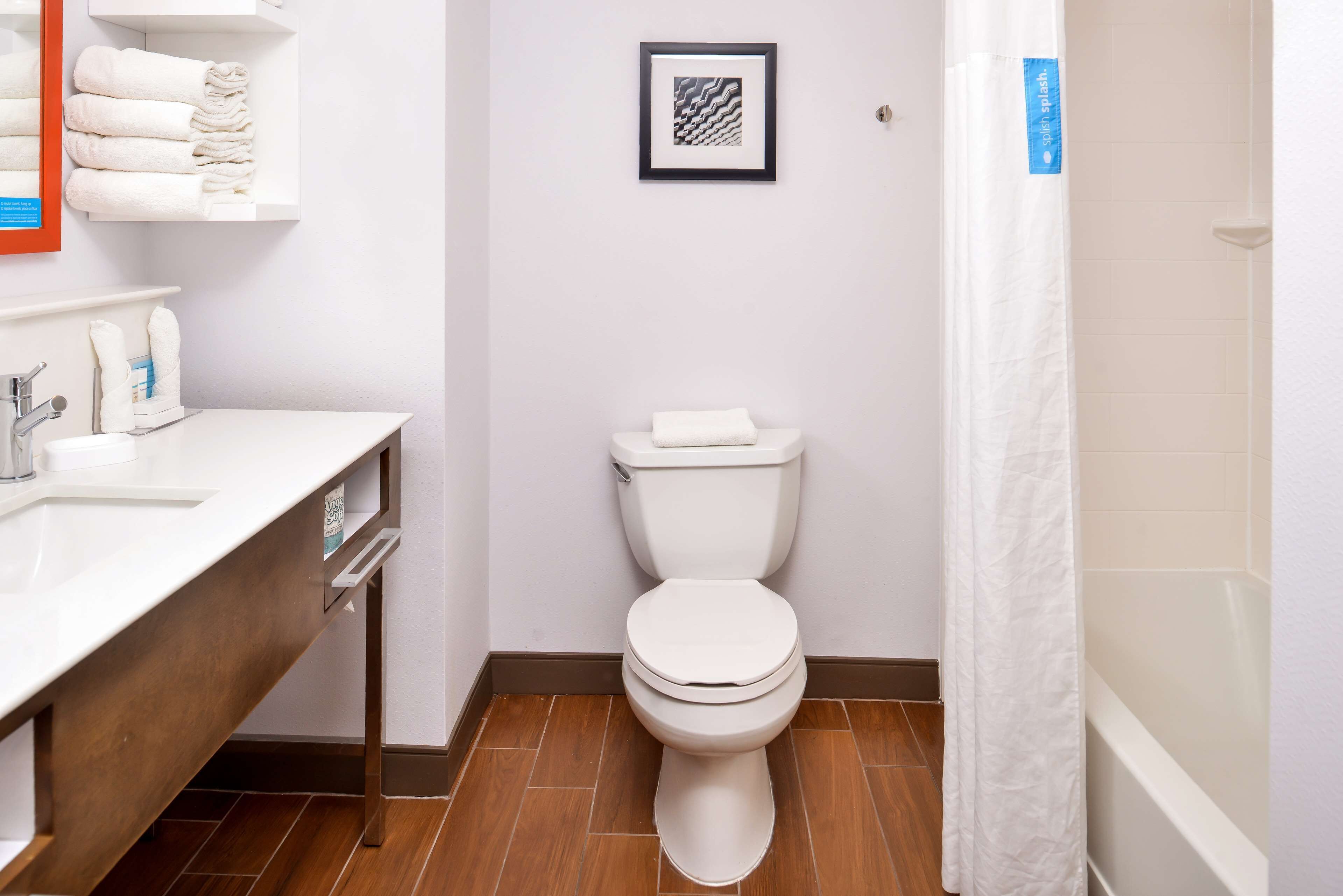 Een badkamer met toilet, wastafel en douchegordijn.