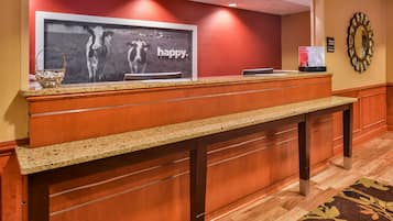 A reception desk with a framed picture of cows and the word "happy."