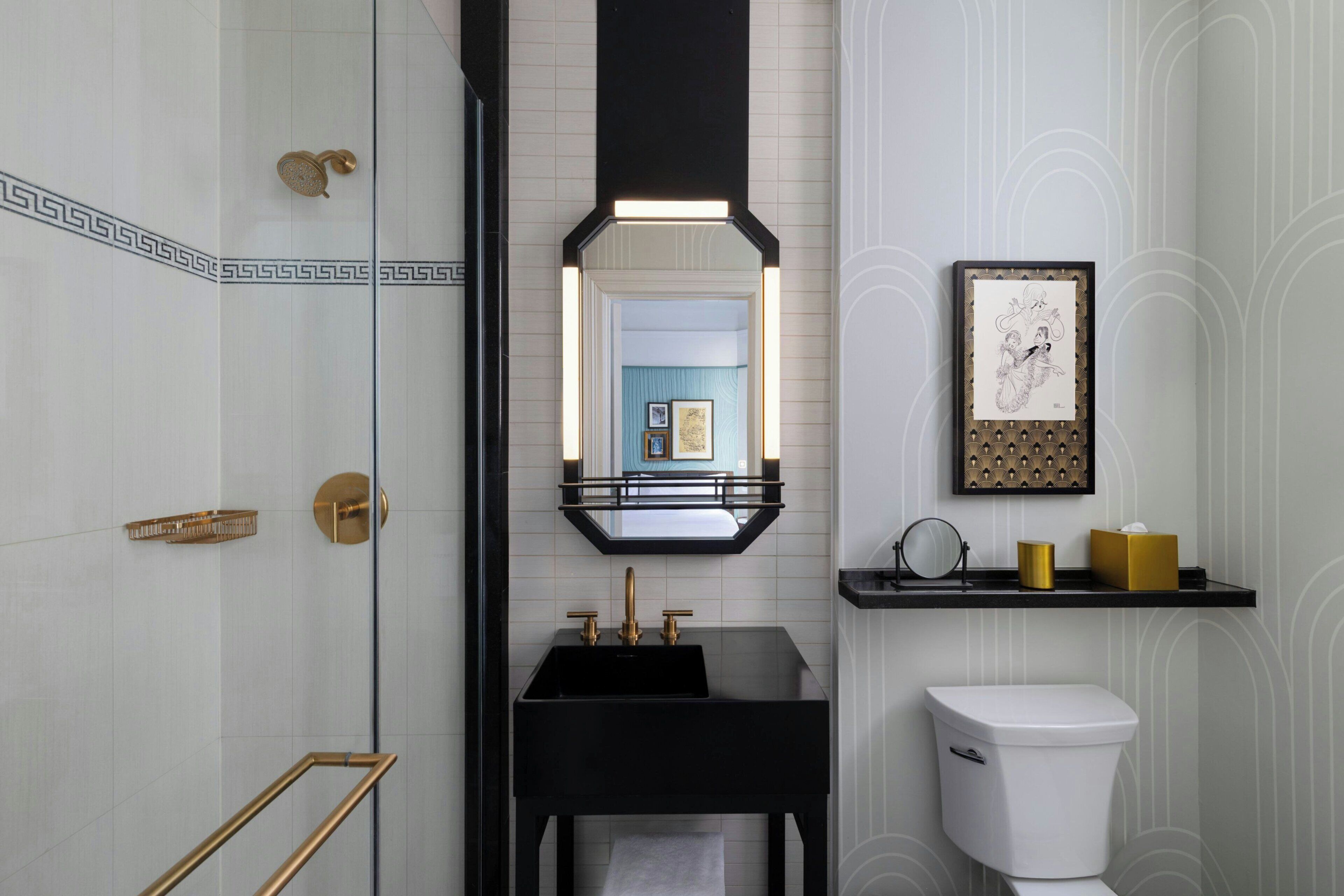 A modern bathroom with a black sink, a white toilet, and a glass shower enclosure.