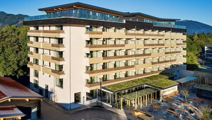 A multi-story hotel with a flat roof, balconies, and a rooftop garden. - Flesslers Lenggries, a Tribute Portfolio Hotel (Lenggries)