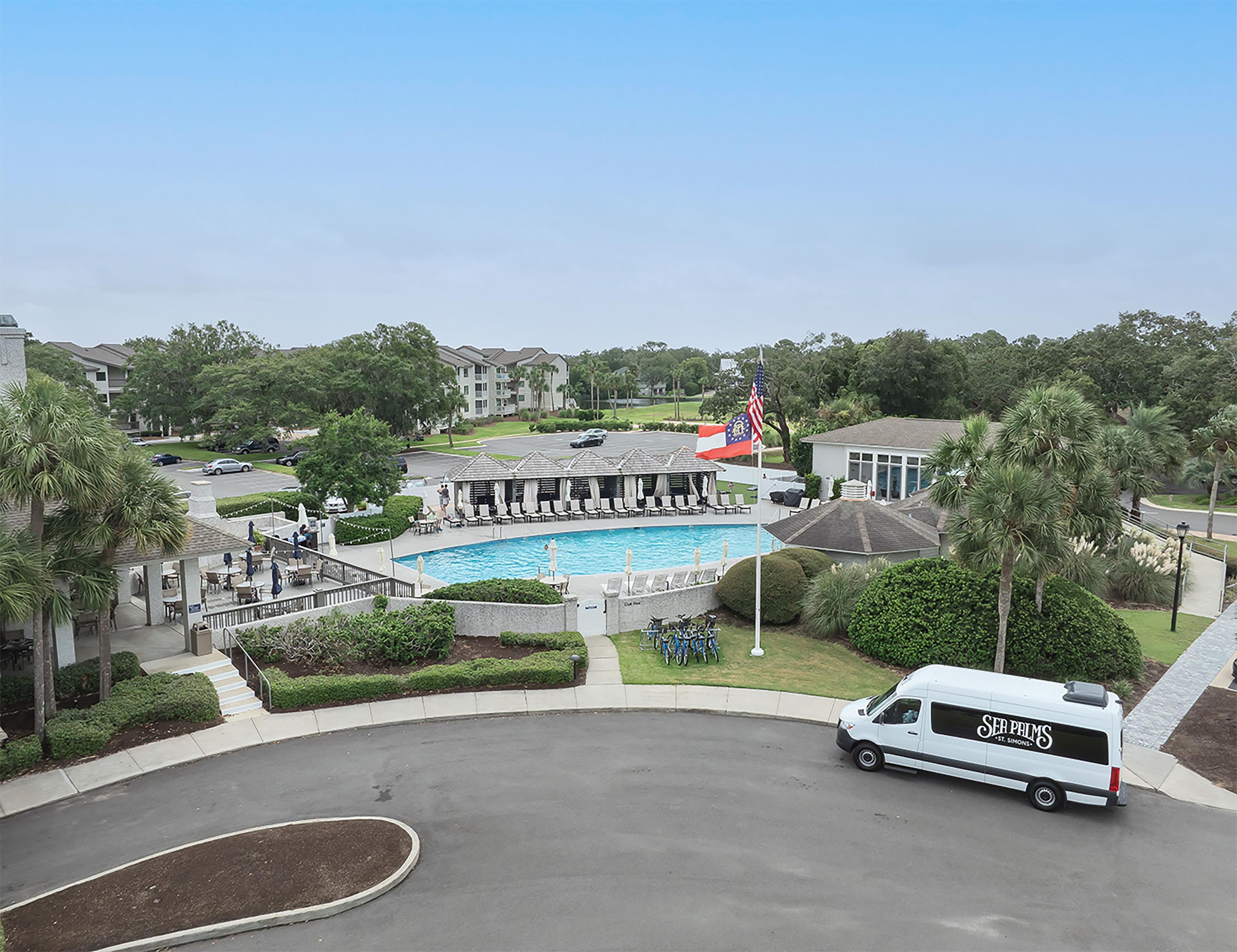 A pool area with lounge chairs, a flag, and a van labeled 'SER PRIMES.'