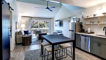 Una cocina moderna con comedor, ventilador de techo y vistas al exterior.