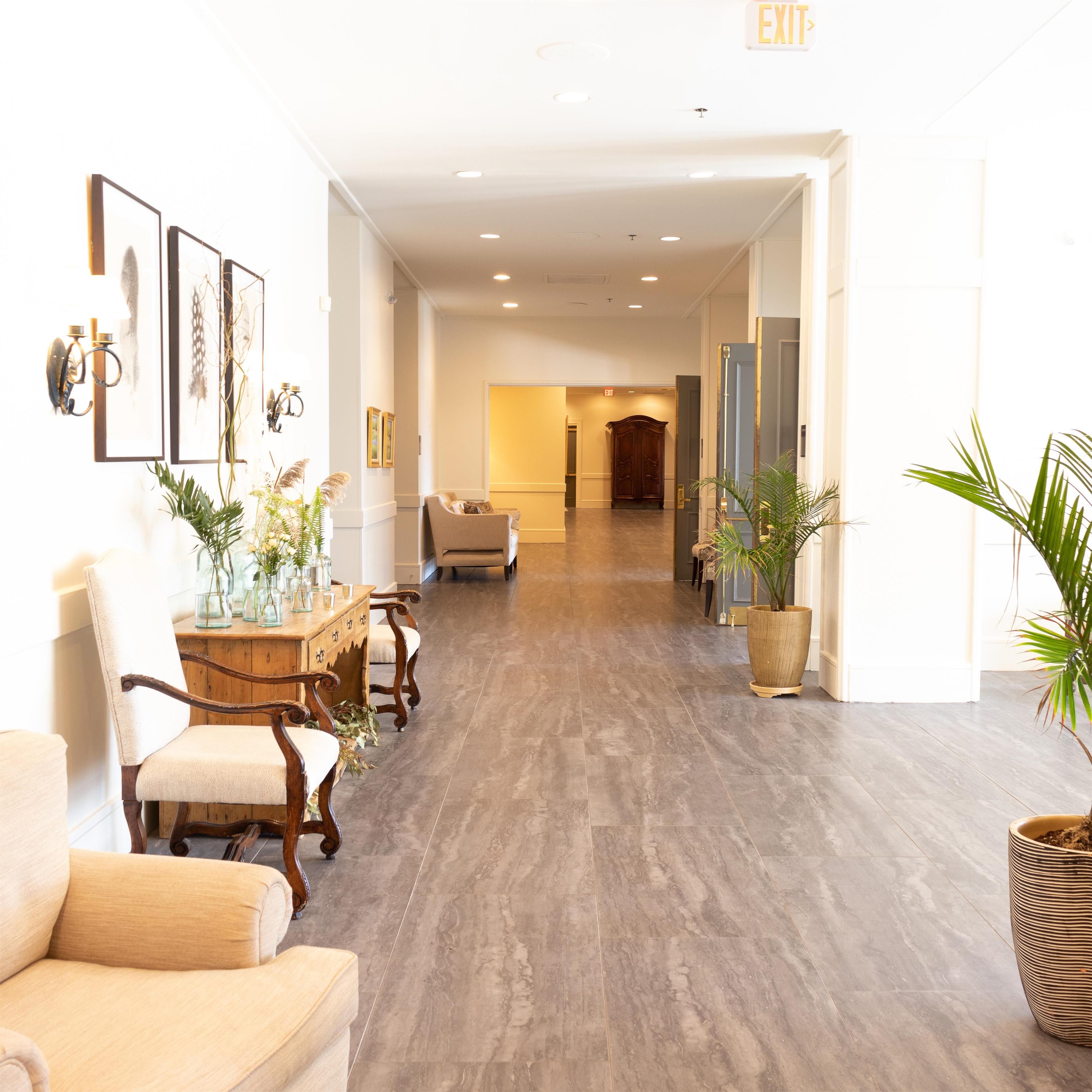 A hotel lobby with a reception desk, seating area, and an exit sign.