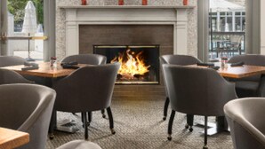 A restaurant with a fireplace, tables, chairs, and a TV mounted above the fireplace. - Sea Palms Resort St Simons Island (St. Simons Island)