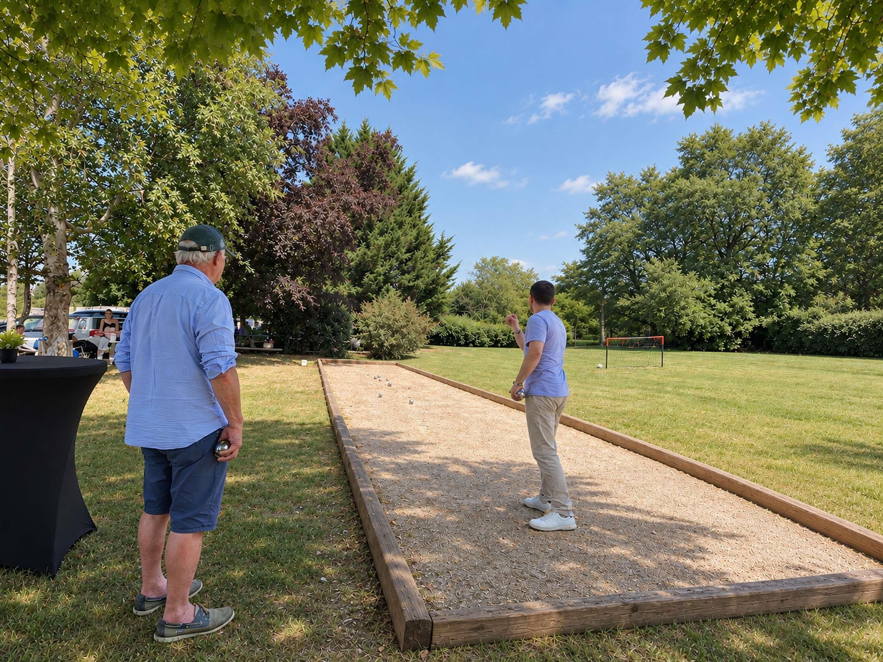 Two people playing a lawn game on a grassy field with trees in the background.