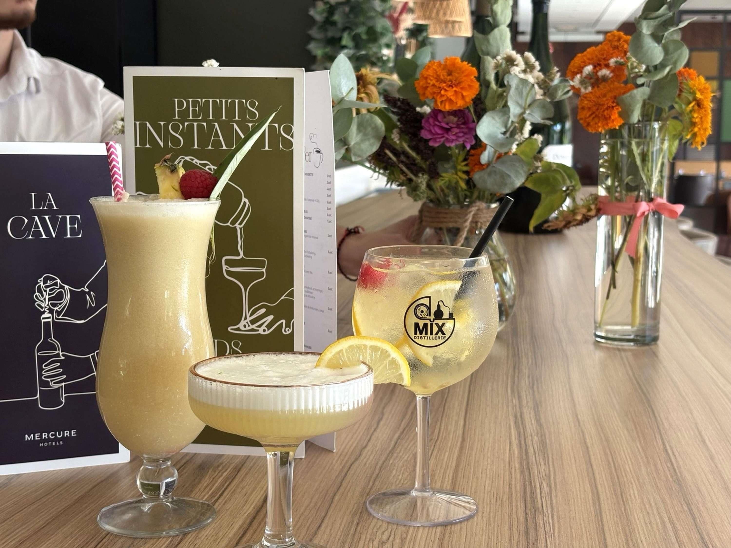 A bar setting with various drinks, a menu, and a floral arrangement.