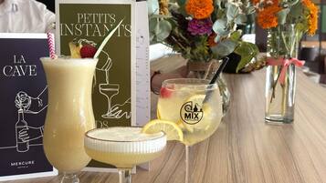 A bar setting with various drinks, a menu, and a floral arrangement.