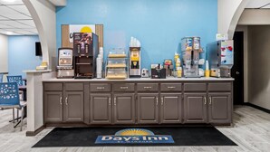 Zona de recepción con estación de café, refrigerador y mostrador con diversos artículos.