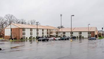 Un motel de varios pisos con estacionamiento.